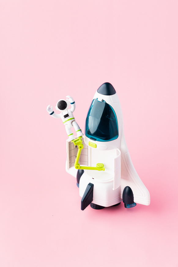 Rocket Model and Astronaut on Pink Background